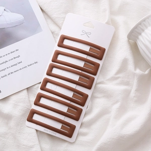 6-piece set of matte brown rectangular snap hair clips on display card with white fabric