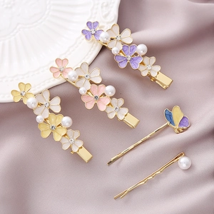 Detail of 5-piece floral hair clip set featuring pearls, rhinestones and enamel petals