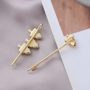 Detail of golden Christmas tree hair clips with letter engraving on purple satin