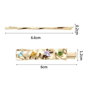 Detail of metal hair clips with geometric colorful crystals and melted texture design