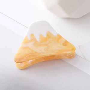 Detail view of acetate Mount Fuji hair claw clip with snow-white top and amber marble base