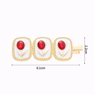 Detailed view of tulip hair clip with dimensions 6.1cm by 2.2cm and red crystal inlay