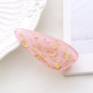 Pink marble hair clip with gold leaf flakes in a translucent resin water drop design