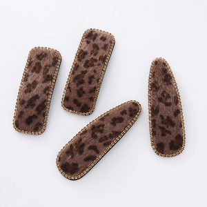 Close-up of leopard print hair clips with velvet texture and sparkling rhinestones