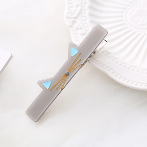Cute gray acetate cat hair clip with blue ears and gold whiskers on elegant lace plate
