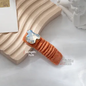 Dettaglio di un fermaglio per capelli in maglia arancione 7x2cm con orsetto in cristallo