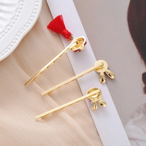Detail of golden rabbit hair clips and festive red tassel accessories on silk