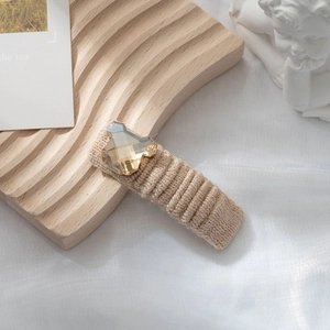 Dettaglio di un fermaglio per capelli a orsetto con cristallo champagne e lana kaki