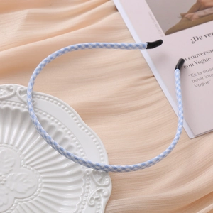 Minimalist blue and white checkered fabric headband displayed on an elegant ceramic plate