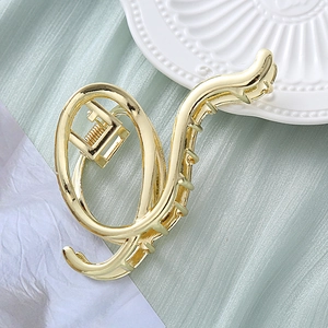 Elegant large gold metal hair claw clip with a streamlined twist design for thick hair