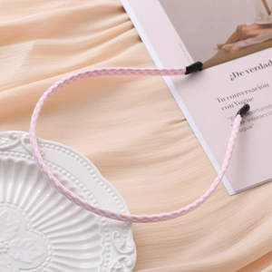 Pink and white plaid fabric headband for women on a beige decorative background