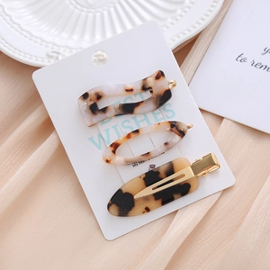 Three-piece set of tortoise shell acetate hair clips on elegant white display cards