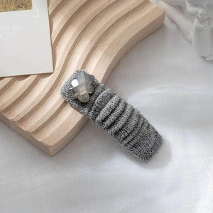 Dettaglio molletta per capelli BB in maglia grigia con fiore di cristallo