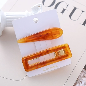 Detail of amber marble acetate hair clips set with golden metal alloy spring clips