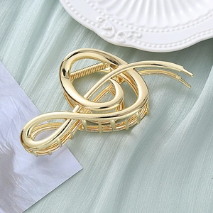 Elegant gold metal hair claw clip in a unique musical treble clef note shape design