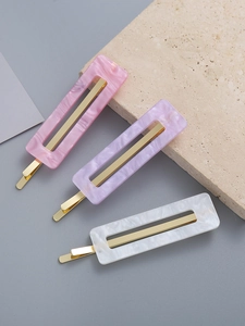 Detailed close-up of three marbled acrylic hair clips in pink, purple, and white