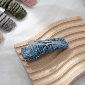 Dettaglio della trama a maglia blu su una clip su un supporto in legno naturale