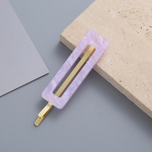 Minimalist light purple marble acrylic hair clip with golden metal base on gray background
