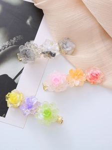 Detailed macro view of three floral acetate hair clips with resin petals and metal grip