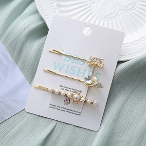 Détail de trois élégantes pinces à cheveux avec strass et perles sur une carte cadeau
