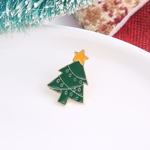 Detailed view of an alloy Christmas tree brooch with green enamel and gold plating