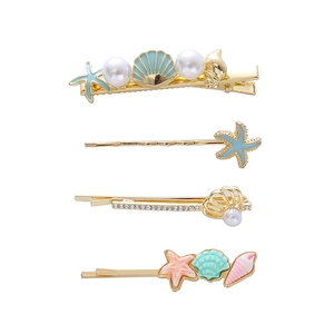 Detail of starfish and shell hair clips set with pearls and rhinestones on gold base