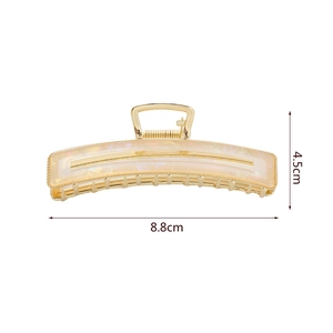 Details einer 8,8 cm goldenen Haarklammer aus Metall mit cremefarbenem Acryl-Inlay
