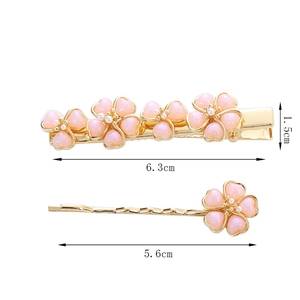 Detailansicht goldener Blumen-Haarklammern mit rosa Harzblüten und weißen Perlen