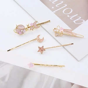 Detail of 5-piece pink star and moon hair clip set with pearls and gold metal base