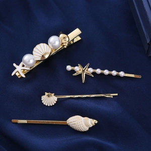 Elegant gold ocean hair clip set with pearls, starfish and shells on blue velvet