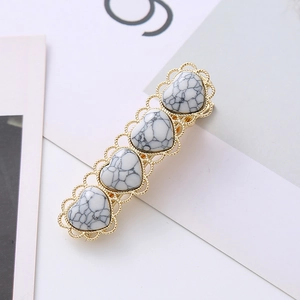 Vintage gold hair clip featuring four heart-shaped white turquoise stones with lace edge