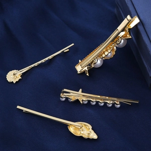 Elegant gold starfish and pearl hair clip set on deep blue silk background