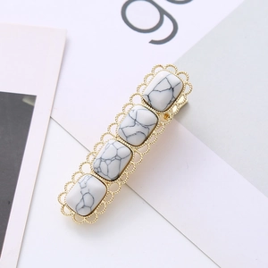 Detail of square hair clip with white turquoise marble stones and gold lace metal frame