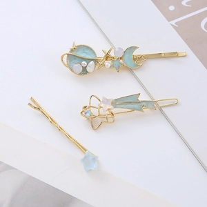 Three-piece set of celestial hair clips with moon and stars in pastel blue and gold