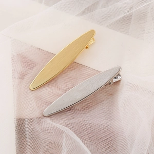 Nahaufnahme matter, gebürsteter Metall-Haarspangen in Gold und Silber mit ovalem Design