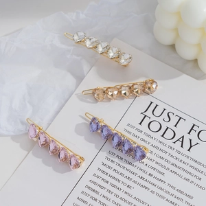Detailed close-up of heart-shaped crystal hairpins in champagne and pink pastel colors