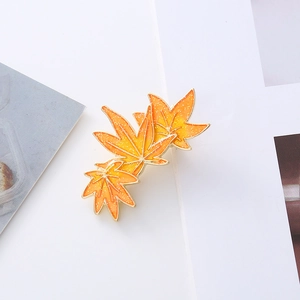 Glittery autumn maple leaf hair clip with orange gradient and gold metallic edges