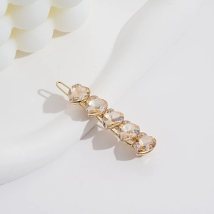 Elegant gold hair clip featuring five champagne heart-shaped crystals for a chic look
