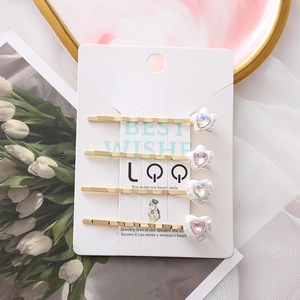 Barokke haarclips set met parels en bedeltjes van hart en ster op een displaykaart