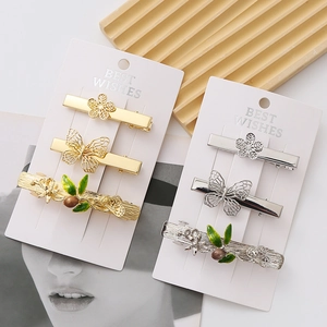 Exquisite gold and silver floral butterfly hair clips set with green leaf details
