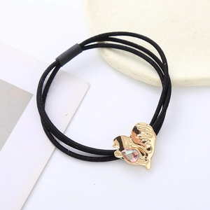 Minimalist elastic hair tie with golden heart charm and crystal stone on white background
