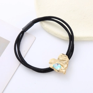 Elastic black hair tie with a gold heart pendant featuring a blue crystal stone