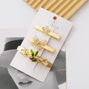 Detailed macro view of a 3-piece golden alloy hair clip set with butterfly and floral motifs