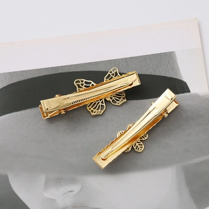 Close-up of dual golden butterfly hair clips with intricate hollow wing design details