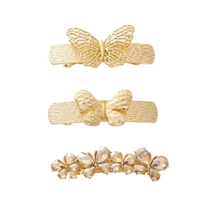Three-piece gold butterfly and rhinestone floral spring hair clip set on white background