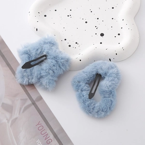 Detailansicht weicher blauer Plüsch-Haarspangen in Stern- und Herzform mit schwarzen Clips