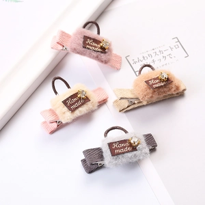 Plush handbag-shaped hair clips in four soft colors with crystals and handmade labels