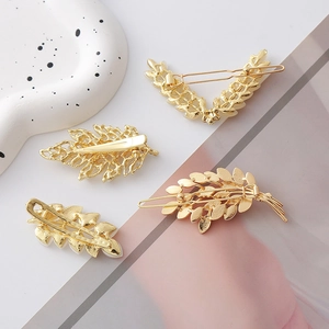 Vue arrière de quatre barrettes dorées en forme de feuilles avec clips crocodiles robustes