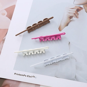 Gros plan de quatre barrettes à cheveux en résine mate avec motifs lapins sur un magazine