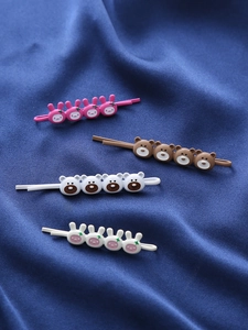 Détail de quatre barrettes à cheveux mignonnes avec lapins et ours sur tissu en soie